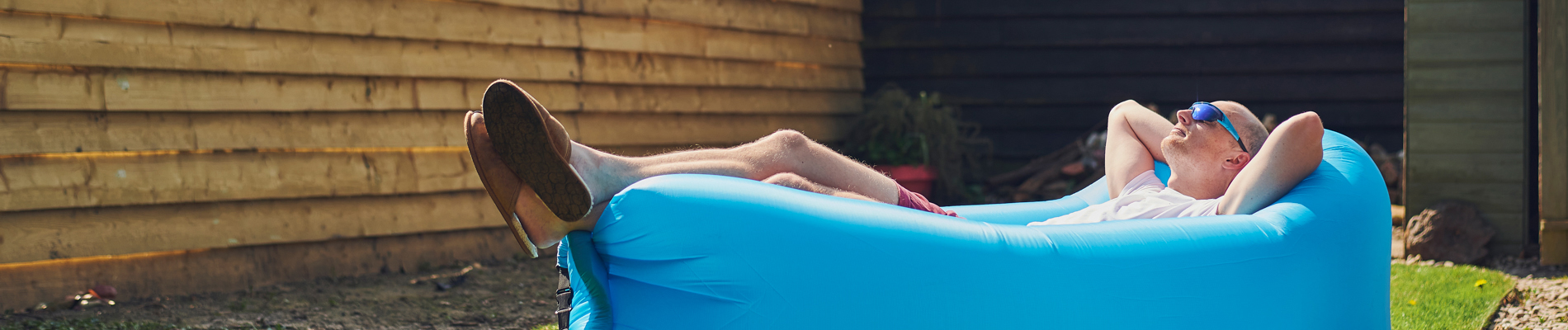 Man laying back in a one person pool enjoying the moment in the sun