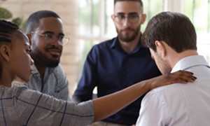 Four individuals having an emotional group conversation